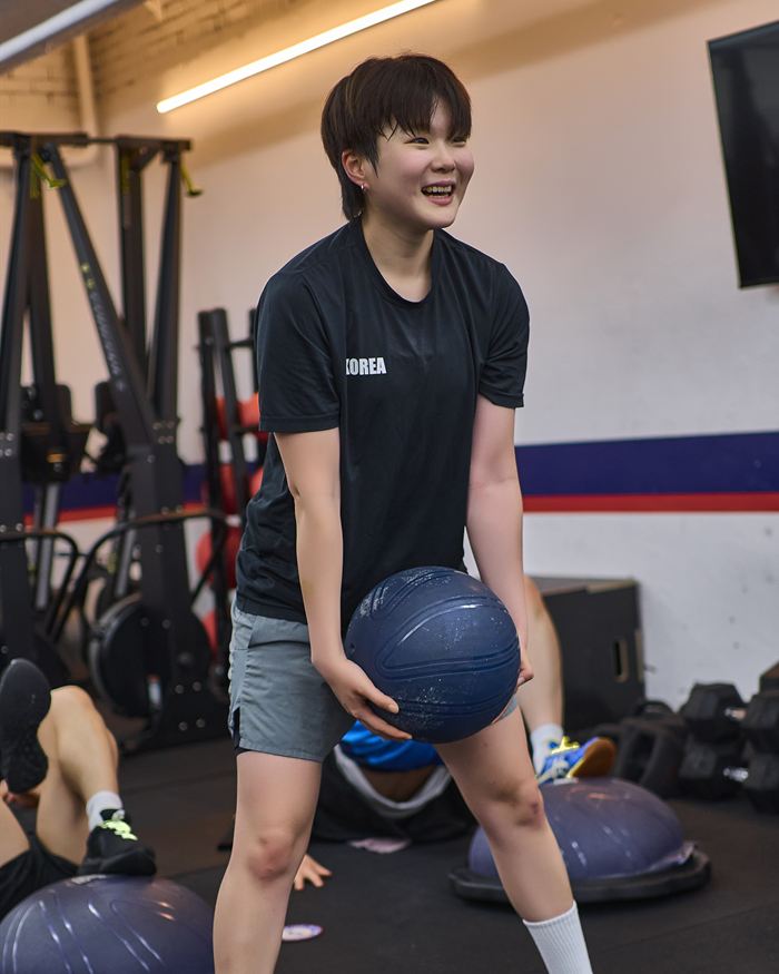 메디신볼을 들고 웃고 있는 코치